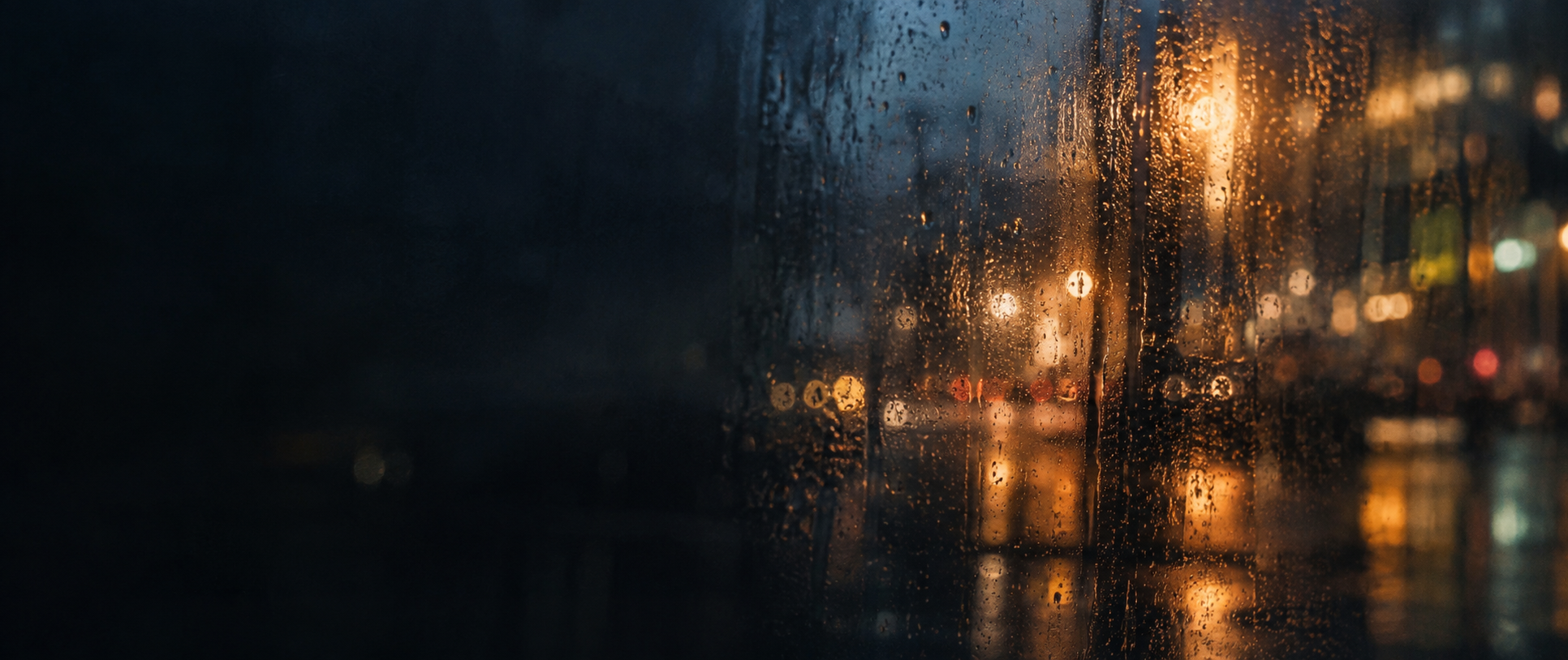 Rain on glass with warm city lights in the background